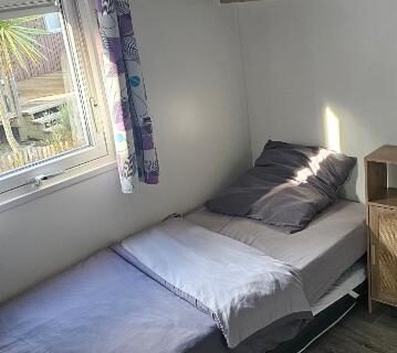 Chambre avec lit simple et fenêtre donnant sur l'extérieur dans Bienvenue au Cap Ferret