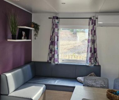 Salon avec banquette, table et climatisation dans le logement Bienvenue au Cap Ferret
