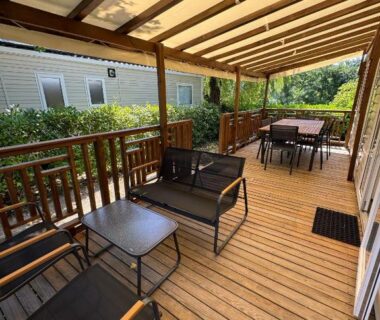 Terrasse couverte avec salon et coin repas au camping Bienvenue chez Jean