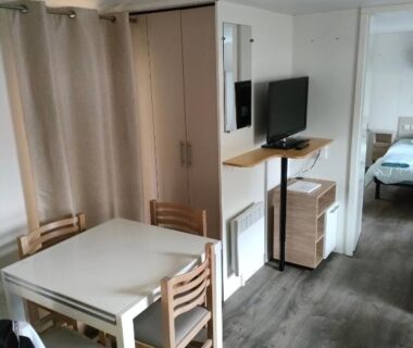 Intérieur avec coin repas et télévision dans le mobil-home Bienvenue chez Jean