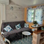 Salon du mobil-home avec canapé et table basse au camping Bleu d'Argonne