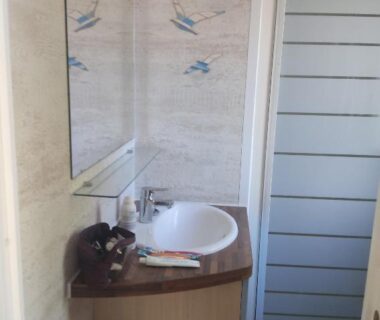 Salle de bain avec lavabo et cabine de douche au camping Bleu d'Argonne