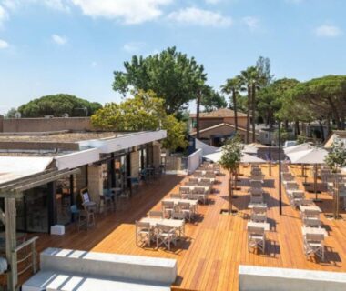 Terrasse en bois avec tables et chaises du Blue Camargue Le Grau du Roi