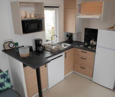 Coin cuisine avec évier micro-ondes et réfrigérateur dans le mobilhome Blue Camargue Le Grau du Roi