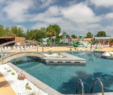 Piscine avec pont et toboggans au camping Blue Camargue Le Grau du Roi
