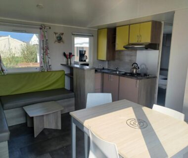 Intérieur avec salon coin repas et kitchenette dans le mobil-home Bora Bora