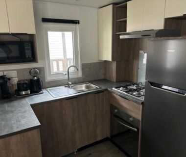 Cuisine équipée avec évier plaque de cuisson four micro ondes et réfrigérateur dans le mobil home Bora Bora 6-8 personnes