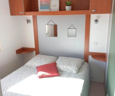 Intérieur chambre avec lit double et rangements muraux dans le Bungalow