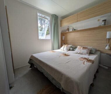 Chambre avec lit double et tête de lit en bois dans le Bungalow