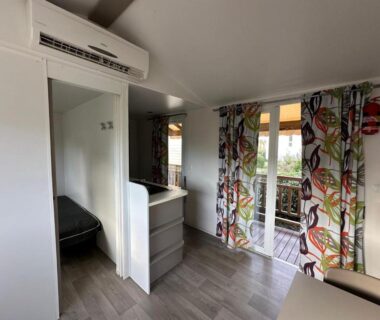 Intérieur lumineux avec terrasse accessible et rideaux colorés du Bungalow 4-6 personnes