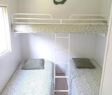 Chambre avec deux lits simples et lit en hauteur dans le Bungalow