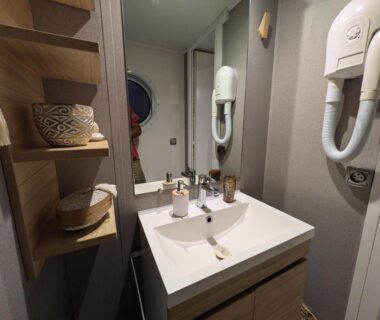 Salle de bain avec lavabo et sèche-cheveux dans le Bungalow