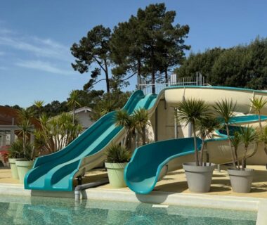 Piscine extérieure avec toboggans et végétation au Bungalow Casita