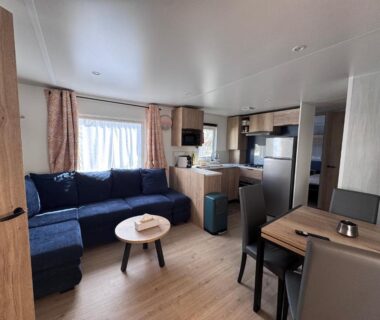 Séjour avec canapé et kitchenette du Bungalow Casita