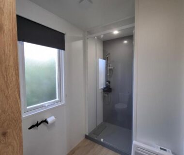Salle de bain avec douche et fenêtre dans le Bungalow Cinéric Nouveau 2026