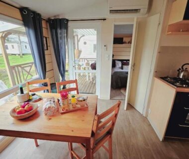 Séjour avec table, chaises et kitchenette du Bungalow Cosy équipé