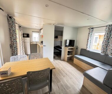 Séjour avec coin repas canapés et télévision dans le Bungalow Lodge 2 chambres