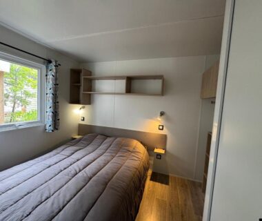 Chambre avec lit double et fenêtre donnant sur l'extérieur dans le Bungalow Lodge 2 chambres