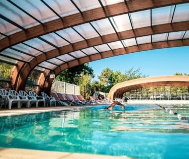 Piscine couverte avec chaises longues et nageur au Bungalow Lodge 2 chambres