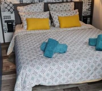 Chambre avec lit double coussins jaunes et serviettes turquoises dans le Bungalow Mobile Home de Luxe Vue Mer Saint-Raphaël