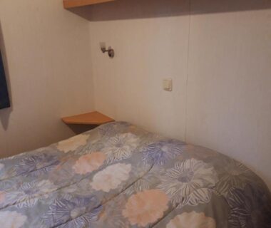 Chambre avec lit double et étagère murale dans le Bungalow a hyeres
