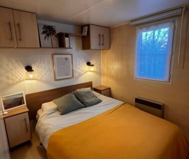 Chambre avec lit double éclairage chaleureux et fenêtre dans le Bungalow bord de Lac Biscarosse