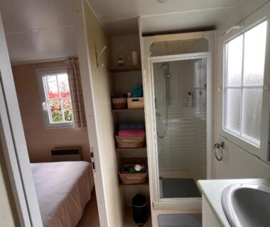 Intérieur avec douche lavabo et lit dans le Bungalow bord de Lac Biscarosse