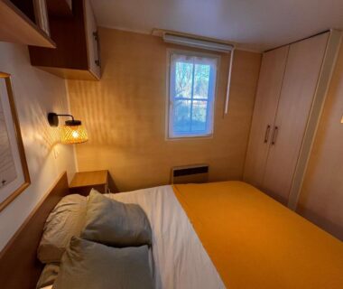 Chambre avec lit fenêtre et rangements dans le Bungalow bord de Lac Biscarosse