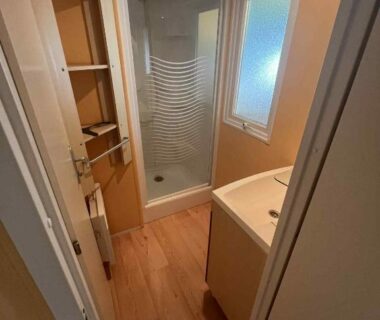 Salle de bain avec cabine de douche et lavabo dans le Bungalow camping Bel Air Village