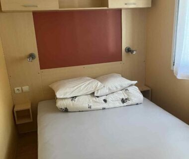 Chambre avec lit double et rangements dans le Bungalow camping Bel Air Village