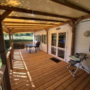 Terrasse couverte en bois avec table et chaises du bungalow du camping Bel Air Village