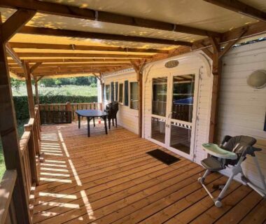 Terrasse couverte en bois avec table et chaises du bungalow du camping Bel Air Village