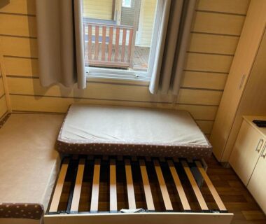 Chambre intérieure avec lit partiellement démonté dans le Bungalow camping la Berge fleurie