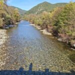 Rivière et berges avec collines et ciel bleu au Bungalow camping la Berge fleurie