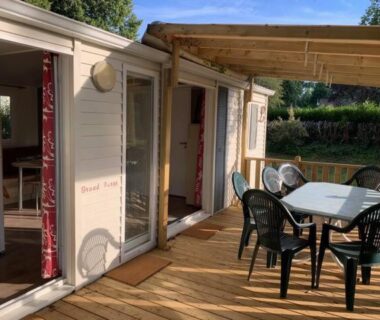 Terrasse en bois avec table et chaises au bungalow climatisé dans un bel écrin de nature