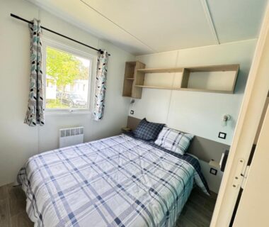 Chambre avec lit double, fenêtre et étagères dans le Bungalow du bassin