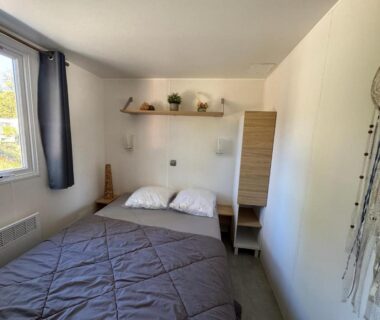 Chambre avec lit double fenêtre et décor mural dans le Bungalow du bonheur