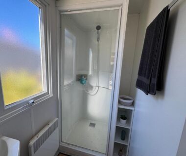 Salle de bain avec cabine de douche dans le Bungalow du bonheur