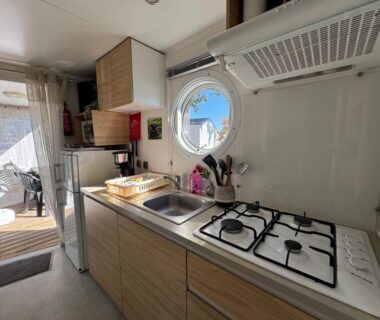 Cuisine équipée avec cuisinière et hublot dans le Bungalow du bonheur au Camping les viviers