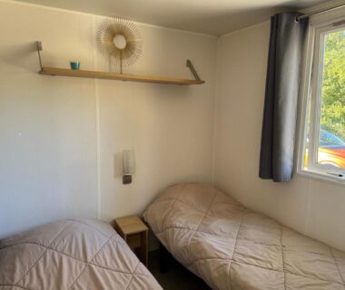 Chambre avec deux lits et fenêtre dans le Bungalow du bonheur