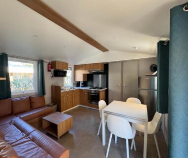 Séjour avec cuisine équipée et canapé dans le Bungalow jardin les Viviers cap-ferret
