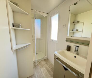 Salle de bain avec douche cabine lavabo et étagères du Bungalow les Embruns