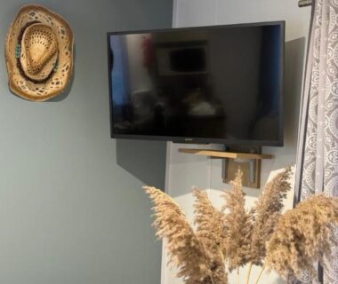 Coin séjour avec télévision murale et vase de pampas dans le Bungalow les Embruns