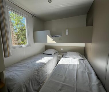 Chambre avec deux lits simples et fenêtre dans le Bungalow les Embruns