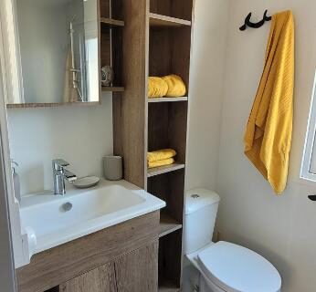 Salle de bain avec lavabo toilettes et étagères du Bungalow neuf 6 places au calme