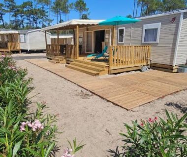 Terrasse avec parasol et pinède du Bungalow neuf 6 places au calme proche océan et lac