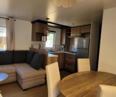 Salon avec coin repas et cuisine ouverte dans le Bungalow neuf 6 places au calme proche océan et lac