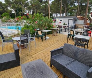 Terrasse en bois avec salon extérieur et piscine du Bungalow neuf 6 places au calme proche océan et lac