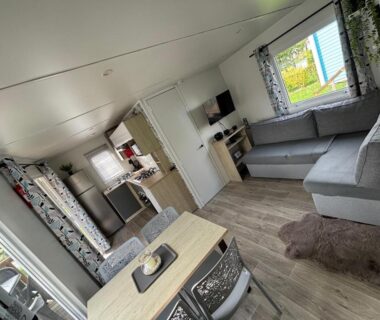 Intérieur avec coin salon, kitchenette et table du Bungalow tout confort 6 personnes