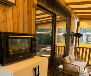 Terrasse couverte avec four et fauteuil en rotin dans le bungalow Bungalows Cap-Ferret BandB La conciergerie